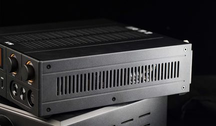 Must metallist musta värvi elektroonikakorpus, vaade kolmeveerand nurga alt, külgmised õhuavad, esiküljel rihveldatud nupud ja ümmargused helisisendid/–väljundid