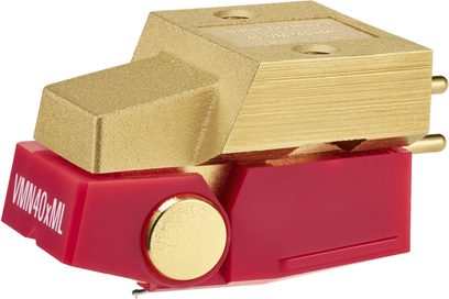 Prenoska pre gramofón Audio Technica AT-VM740xML, pohľad z pravého predného trojštvrťového uhla, horné puzdro z textúrovaného zlatého kovu s dvoma závitovými otvormi, spodná časť z červeného plastu s označením VMN40xML, zlatý dekoračný disk a dva zlaté valcové piny na zadnej strane