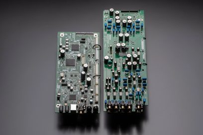 Dvě zelené elektronické desky s mnoha elektronickými součástkami a konektory, pohled zepředu