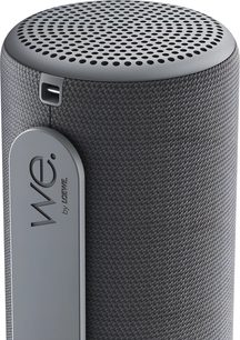 Tragbarer Bluetooth-Lautsprecher Loewe We. HEAR 1 grau, Nahaufnahme mit perforiertem Gitter und seitlicher Trageschlaufe mit Logo