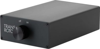 Juodas Transrotor Phono Studio fonopreamplifikatorius iš šlifuoto aliuminio, kompaktiškas stačiakampis korpusas, matomas iš dešinės priekinės pusės, su juodu centriniu besisukančiu mygtuku, žalia LED lempute ir keturiais kampiniais varžtais