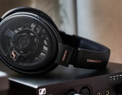 Casque hi-fi ouvert Sennheiser HD 660S2 noir posé sur ampli audio, grilles métal et logo doré bien visibles