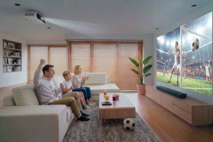 Ceiling-mounted projector displaying a football match on a large screen in a family living room