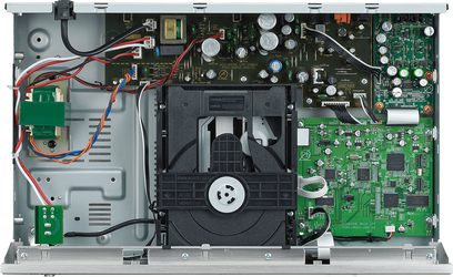 Innenansicht eines CD-Players mit grünen Leiterplatten, elektronischen Bauteilen, farbigen Kabeln und silbernem Lese-Mechanismus