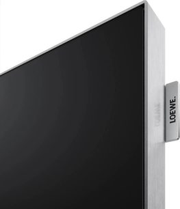 Loewe Vega 43-TV svart med ramme i børstet sølv, nærbilde av hjørnet med sidelogо