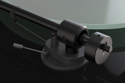 Um braço de toca-discos preto com um contrapeso cilíndrico, uma base circular e uma alavanca metálica sobre uma superfície escura