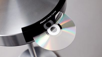 Domácí kino Elipson Music Center v bílé barvě, detailní pohled zepředu na integrovaný CD přehrávač s duhovými odlesky