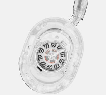 Nærbillede af en gennemsigtig øretelefon med synlige indre komponenter, oval form, cirkulære detaljer og metaldele