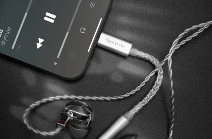 Hõbedane Questyle audio-DAC ühendatud nutitelefoniga, läbipaistva keerutatud kaabli ja kõrvasiseste kõrvaklappidega