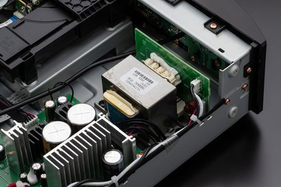 Interior view of a black Marantz CD6007 CD player showing the electronic components, transformer, and disc reading mechanism