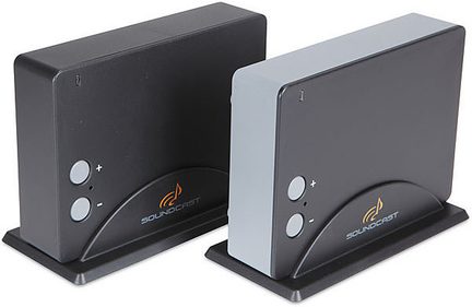 Two rectangular black cases with gray front panels, buttons and ports on the front, resting on a shiny black stand
