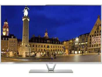 Centrální náměstí města v noci s osvětlenou fontánou, nasvícenými historickými budovami a kolemjdoucími