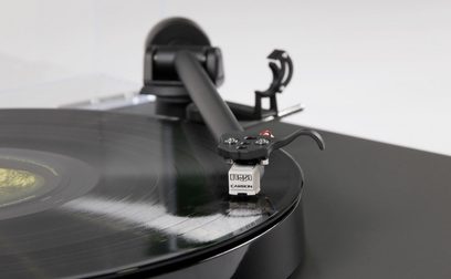 Rega Planar 1 pladespiller i lamineret træ, tæt ovenfra-billede af tonearmen med pickup og modvægt