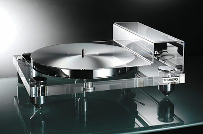 Gennemsigtig Thorens TD 2010 pladespiller set ovenfra i et skråt perspektiv, med lukket låg, tonarm, pickup og modvægt