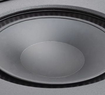 Svart cirkulär yta med en slät central kon, omgiven av en texturerad kant och en cirkulär ram