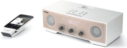 Yamaha TSX-W80, kompakt hvid audio-dockingstation med LED-skærm, 3 runde højttalere på forsiden og en iPhone placeret ovenpå, set forfra