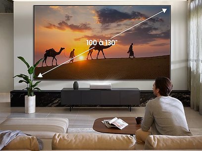 Videoprojektor Samsung The Premiere SP-LSP9TFA promítá obraz karavany velbloudů v poušti při západu slunce