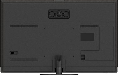 Bagside af Panasonic TV-55Z95B højopløsnings-tv i mat sort plast, med rektangulært kameramodul med tre linser centreret øverst, vandrette ventilationsåbninger, vægbeslagspunkter og sort metalcenterfod