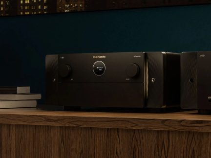 Black metal AV preamplifier with a front panel featuring two large knobs and a circular display, three-quarter view