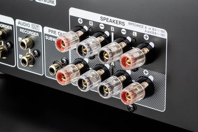 Forgylte og svarte RCA-lydkontakter på den grå metallbakpanelen til en Denon PMA-900HNE hi-fi stereoanlegg