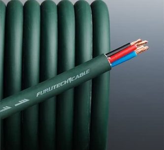Furutech u-2T mørk grøn lydkabel, bipolær kobber, liggende på grå overflade foran grøn rørradiator