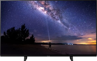 Panasonic TX-48JZ1000E-tv, der viser en stjernebestrøet himmel med Mælkevejen og en menneskelig silhuet på en strand i tusmørket