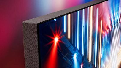 Televisore ad alta definizione Philips 65OLED959 nero con cornice sottile in metallo scuro, lato sinistro rivestito in tessuto grigio testurizzato, primo piano obliquo sull’angolo superiore sinistro