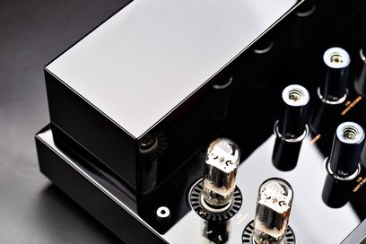 Cayin CS-6PH high-end effektforsterker, sort lakkert metallchassis sett i nærbilde ovenfra med rektangulært, skinnende transformatorlokk og to elektronrør i glass montert på sirkulære sokler
