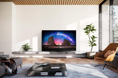 Téléviseur Panasonic TX-65MZ2000E affichant un paysage rocheux au coucher du soleil, dans un salon moderne et lumineux