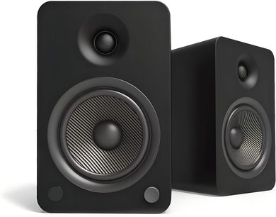 Sort Kanto YU6 trådløst højttalerpar, mat kabinet set fra venstre forperspektiv, rektangulær kasse med afrundede hjørner, sort dome-diskant, stor woofer med tekstureret overflade omkranset af grå og to små runde knapper nederst på fronten