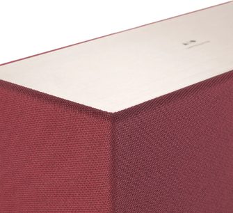 Raudonai oranžinė "Triangle AIO 3" garso kolonėlė, artimas viršutinio kampo vaizdas, rodantis raudoną tekstilinę apdailą ir baltą rėmelį