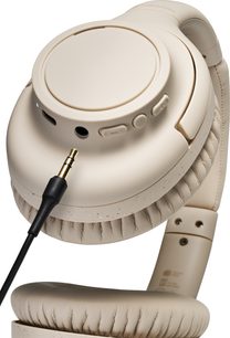 Căști wireless Audio Technica ATH-S300BT bej, vedere de aproape, cască stângă, pernițe căptușite, cablu audio introdus