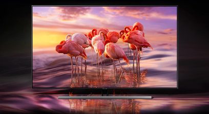 Flamingofugle i vandet ved solnedgang, orange himmel med skyer, spejlinger i det stille vand