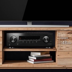 Amplificador home theater Pioneer VSX-534 preto, vista frontal aproximada, em móvel de TV de madeira clara, altura 148 mm