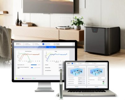 Sort subwoofer med ARC Genesis-kalibreringssoftware vist på computer og bærbar computer