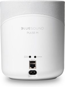 Bezdrátová chytrá reproduktorová souprava BlueSound Pulse M v bílé barvě, pohled zepředu, zaoblený válcový tvar, šedá textilní mřížka, tlačítka a porty na horní straně