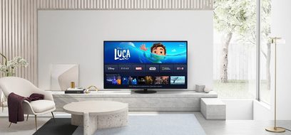 Panasonic TX-48JZ980E-fladskærms-tv, der viser Disney+-grænsefladen i en moderne stue med hvid sofa og stenbordplade