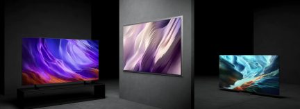 Tre televisori a schermo piatto che mostrano paesaggi astratti colorati, presentati frontalmente e con una leggera angolazione