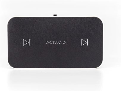 Rektangulær, mattsort netværksaudioafspiller Octavio set oppefra, hvidt logo i midten, bagstillede stik