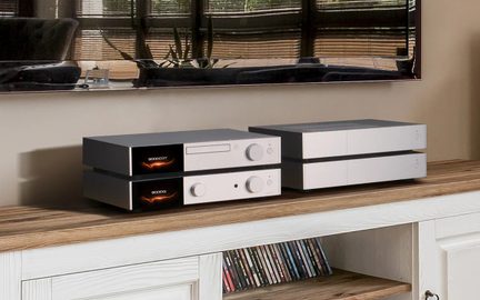 Hi-fi reťazec Audiolab 9000 so strieborným CD prehrávačom 9000CDT a zosilňovačom 9000A, poukladanými na seba na drevenom TV stolíku