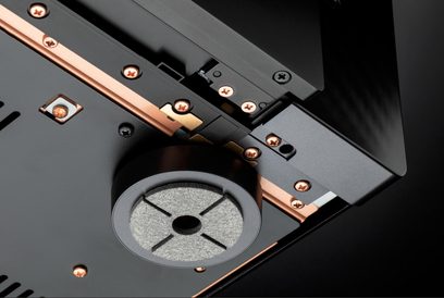 Stambiu planu iš apačios matomas juodas Marantz AV 20 namų kino stiprintuvas-preamplifikatorius: matinio metalo korpusas su variniais bėgeliais, varinėmis varžtais ir dideliu apvaliu metaliniu bei veltiniu slopinančiu kojeliu.