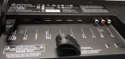 Zadní panel audio zařízení Sennheiser s porty USB, HDMI, Ethernet a audio konektory. Varování před rizikem úrazu elektrickým proudem