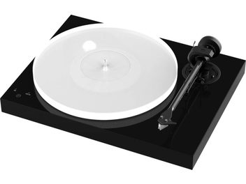 Pro-Ject X1 Piano čierna gramofónová doska, pohľad zhora, biely kruhový tanier, čierny rameno tonearmov, na lesklom čiernom obdĺžnikovom podstavci