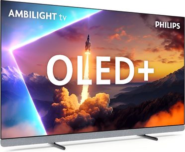 Philips 65OLED910 högupplöst TV i svart med extra tunn metallram, platt OLED+-skärm, nedre kant täckt av grått tyg, står på två brett isärplacerade metallfötter, sedd snett framifrån