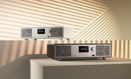 Due radio da tavolo, una bianca e una marrone scuro, con griglie metalliche geometriche, schermo centrale "sonoro", vista a tre quarti