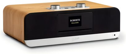 Rektangulært bordradio Roberts BluTune 300 i lys træ med blank sort front, sølvfarvet aluminiumsbund, centralt farveskærm og to metaldrejeknapper på toppen, set fra venstre forfra i trekvarts vinkel