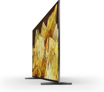 Sony XR85X90L TV, set fra siden, slankt skærm, rektangulær stander, billede af gule krystaller, hvid baggrund