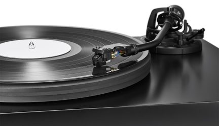 juoda Audio-Technica vinilinė patefonas stambiu planu, tonarmis ant juodos plokštelės su baltu etikete