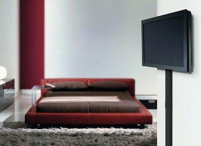 Rød sofa på gråt tæppe, sort fladskærm på vægbeslag på hvid væg, moderne minimalistisk indendørs