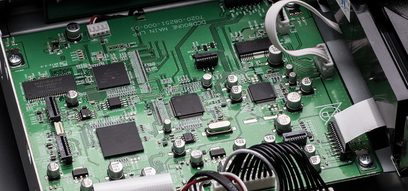 Grüne Leiterplatte mit elektronischen Bauteilen, Chips, Kondensatoren und Steckverbindern, Nahaufnahme von oben